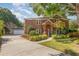 Elegant brick home with a well-manicured lawn and a long driveway leading to a detached garage at 343 Raleigh Pl, Oviedo, FL 32765