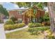 Charming brick home featuring a red front door, lush landscaping, and mature trees at 343 Raleigh Pl, Oviedo, FL 32765