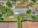 An aerial view of a single-story home with a screened-in porch, fenced yard, and lush surrounding trees at 4604 S Shore Rd, Orlando, FL 32839