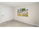 Well-lit bedroom features wood-look flooring, neutral walls, a door, and a view of the outdoors at 4604 S Shore Rd, Orlando, FL 32839