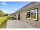 Home's exterior, features stone detail, a well-kept lawn, and ample natural light at 4604 S Shore Rd, Orlando, FL 32839