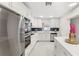 Modern white kitchen featuring stainless steel appliances and a stylish backsplash at 4604 S Shore Rd, Orlando, FL 32839