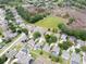 Community aerial showcasing homes with mature trees, and neighborhood layout near green space and pond at 5126 Rishley Run Way, Mount Dora, FL 32757
