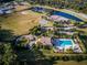Aerial view of community amenities, including a large pool, tennis court, baseball field and pond at 5126 Rishley Run Way, Mount Dora, FL 32757
