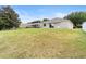 A spacious, grassy backyard with a view of the home's exterior at 5126 Rishley Run Way, Mount Dora, FL 32757
