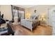 Bedroom with hardwood floors, decorative window treatment, and a white wood framed bed at 5126 Rishley Run Way, Mount Dora, FL 32757