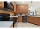 Kitchen showcasing stainless steel appliances, wood cabinets, and a tile backsplash at 5126 Rishley Run Way, Mount Dora, FL 32757
