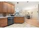 Kitchen with stainless steel dishwasher, countertops, and wood cabinets at 5126 Rishley Run Way, Mount Dora, FL 32757
