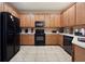 Spacious kitchen with wooden cabinets and black appliances at 5126 Rishley Run Way, Mount Dora, FL 32757