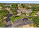 Aerial view of the townhomes with parking in front, lush landscaping, and a lake in the background at 543 Azinger Cir, Orlando, FL 32824