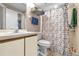 This bathroom features a shower with a patterned curtain, a sink with mirror, and blue and white towels displayed at 543 Azinger Cir, Orlando, FL 32824