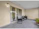 Covered patio featuring neutral stucco walls, gray tile floor, and seating for outdoor relaxation at 543 Azinger Cir, Orlando, FL 32824