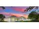 A beautiful backyard view of the home with a colorful sunset in the background at 5839 Tarleton Way, Mount Dora, FL 32757