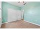 Bedroom with carpet floors, mint green walls, white trim, and a closet with bi-fold doors at 5839 Tarleton Way, Mount Dora, FL 32757