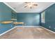 The bedroom features blue walls, carpet flooring, a ceiling fan, a window, and built-in shelving at 5839 Tarleton Way, Mount Dora, FL 32757