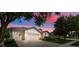 Dusk shot of a lovely home featuring a three-car garage, landscaped yard, and inviting curb appeal at 5839 Tarleton Way, Mount Dora, FL 32757