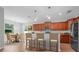 Bright kitchen with wooden cabinets, granite countertops, and a breakfast bar with seating for three at 5839 Tarleton Way, Mount Dora, FL 32757