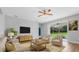 Inviting living room with modern furniture, a large window overlooking the backyard, and neutral décor at 5839 Tarleton Way, Mount Dora, FL 32757