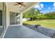 Covered patio looks out onto a large, green backyard with firepit at 5839 Tarleton Way, Mount Dora, FL 32757