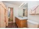 Bathroom features double sinks, a shower with peach-colored curtain, and wood-look floor at 6019 Long Peak Dr, Orlando, FL 32810
