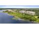 Aerial view displays waterfront condos nestled among lush foliage along a tranquil lake, creating a serene and picturesque setting at 6336 Buford St # 307, Orlando, FL 32835