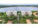 An aerial view showcases two waterfront condos with a central pool, set against a cityscape backdrop and lush greenery at 6336 Buford St # 307, Orlando, FL 32835