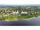 An expansive aerial perspective shows lakeside condos with a dock and pool, amidst mature trees and neighborhood views at 6336 Buford St # 307, Orlando, FL 32835
