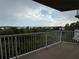 Balcony view with white railings overlooking the lush greenery and water at 6336 Buford St # 307, Orlando, FL 32835