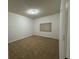 A simple bedroom features neutral carpet and a small window for natural light at 6336 Buford St # 307, Orlando, FL 32835