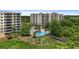 A community pool is nestled between condo buildings, offering a refreshing escape surrounded by green spaces and tropical palm trees at 6336 Buford St # 307, Orlando, FL 32835