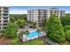 A stunning aerial view reveals a community pool nestled between condos, surrounded by verdant trees and well-manicured lawns at 6336 Buford St # 307, Orlando, FL 32835