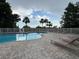 Lounge by the sparkling community pool, surrounded by palm trees and an elegant white fence, perfect for relaxation at 6336 Buford St # 307, Orlando, FL 32835