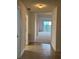 Neutral hallway with both carpet and tile leading to a bright room with a balcony at 6336 Buford St # 307, Orlando, FL 32835