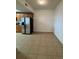 View of the kitchen area featuring stainless steel refrigerator and neutral-toned cabinets and tile floors at 6336 Buford St # 307, Orlando, FL 32835