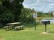 Community picnic area by the lake with picnic table, grill, and signage at 6403 Parc Corniche Dr # 4308, Orlando, FL 32821