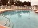 Community swimming pool with fenced lounging area and table umbrellas at 6403 Parc Corniche Dr # 4308, Orlando, FL 32821