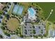 Aerial view of community pool, tennis courts, parking and clubhouse by lake at 6728 Great Bear Dr, Lakeland, FL 33805