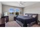 Comfortable bedroom offers a calm color palette, a ceiling fan, and views of the lake at 6728 Great Bear Dr, Lakeland, FL 33805