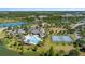 Aerial view of community amenities: clubhouse, swimming pool, playground, and tennis courts near lake at 6728 Great Bear Dr, Lakeland, FL 33805