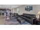 Cozy living room with dark leather furniture, plush rug, and an open view into the eat-in kitchen at 6728 Great Bear Dr, Lakeland, FL 33805