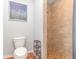Bathroom featuring neutral ceramic tiled shower and convenient toilet placement, plus decorative accents at 7101 Se 124Th St, Belleview, FL 34420