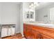 Bathroom featuring double vanity, wooden cabinet, laundry cart, and ample lighting for daily routines at 7101 Se 124Th St, Belleview, FL 34420