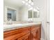 Bathroom featuring double vanity sinks with wood cabinetry and ample counter space at 7101 Se 124Th St, Belleview, FL 34420