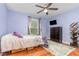 Cozy bedroom with a patterned rug, ceiling fan, window, and wardrobe for a comfortable living space at 7101 Se 124Th St, Belleview, FL 34420