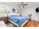 Bright bedroom with a tufted headboard, wood floors, ceiling fan, and natural light from multiple windows at 7101 Se 124Th St, Belleview, FL 34420