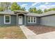 Close-up of the front entrance, displaying the door, gray siding, and landscaping at 7101 Se 124Th St, Belleview, FL 34420