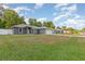Exterior view of the home showcasing its tidy front lawn, gray siding, and an attached two-car garage at 7101 Se 124Th St, Belleview, FL 34420