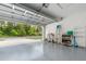 Spacious garage with epoxy flooring, storage shelves, and an open door at 7101 Se 124Th St, Belleview, FL 34420