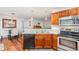Well-lit kitchen featuring wood cabinets, modern stainless steel appliances and a stone countertop with double sink at 7101 Se 124Th St, Belleview, FL 34420