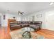 Spacious living room with hardwood floors, ceiling fan, and a plush sectional sofa at 7101 Se 124Th St, Belleview, FL 34420